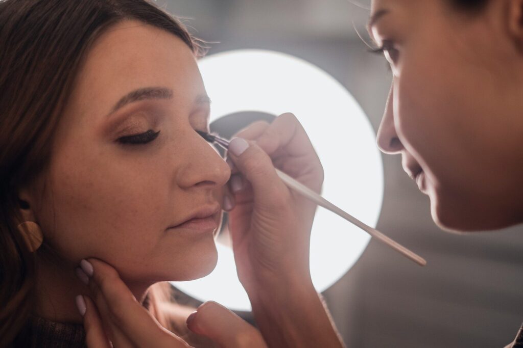 woman putting eyeliner on another woman's eye