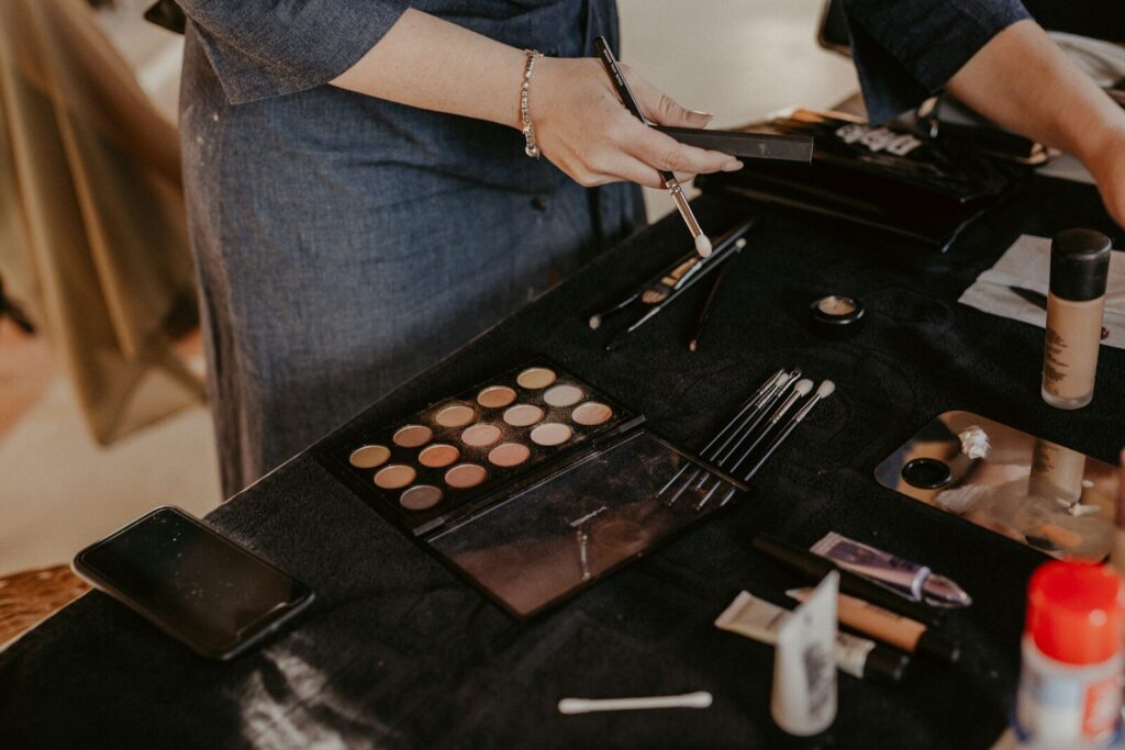a woman is putting makeup on a table